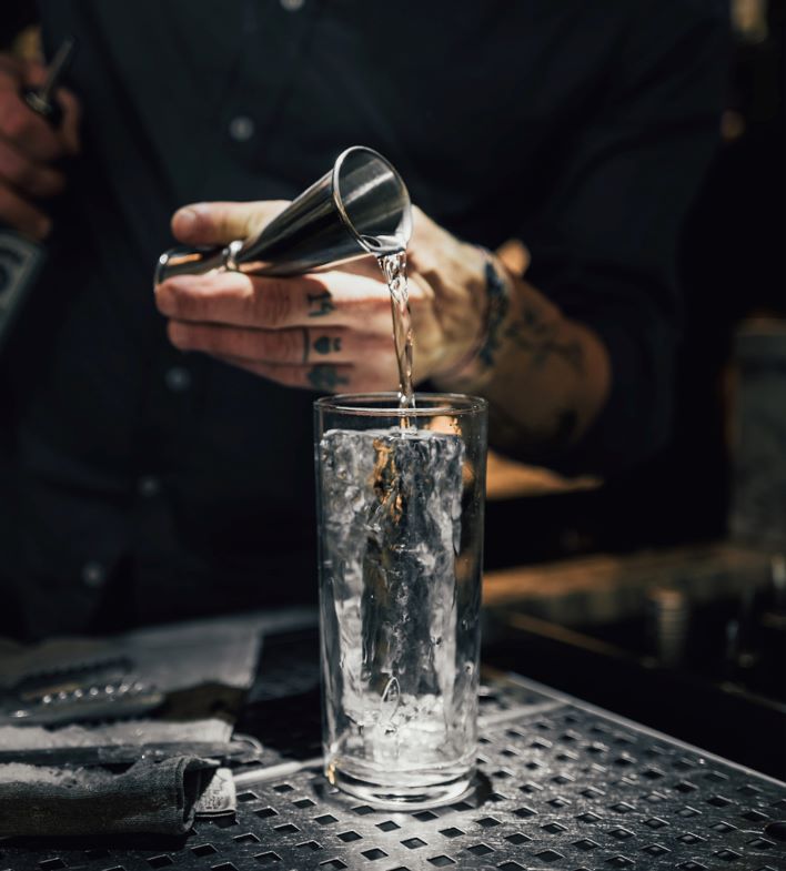 Highball Glas mit Eis für einen Tom Collins Gin Cocktail
