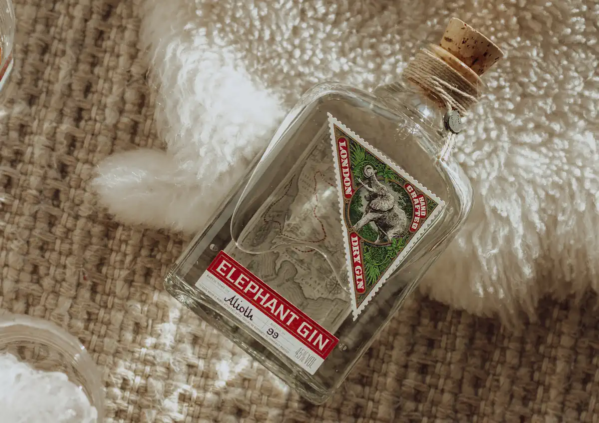 Elephant Gin Flasche auf weißem Fell und Bastmatte