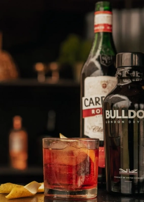 Negroni Cocktail mit Bulldog Gin und Wermut im Hintergrund