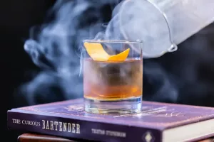 Cocktail mit Rauch auf Büchern