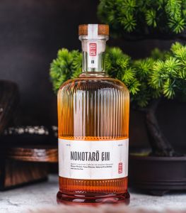 Flasche Momotaro Gin mit Bonsai im Hintergrund
