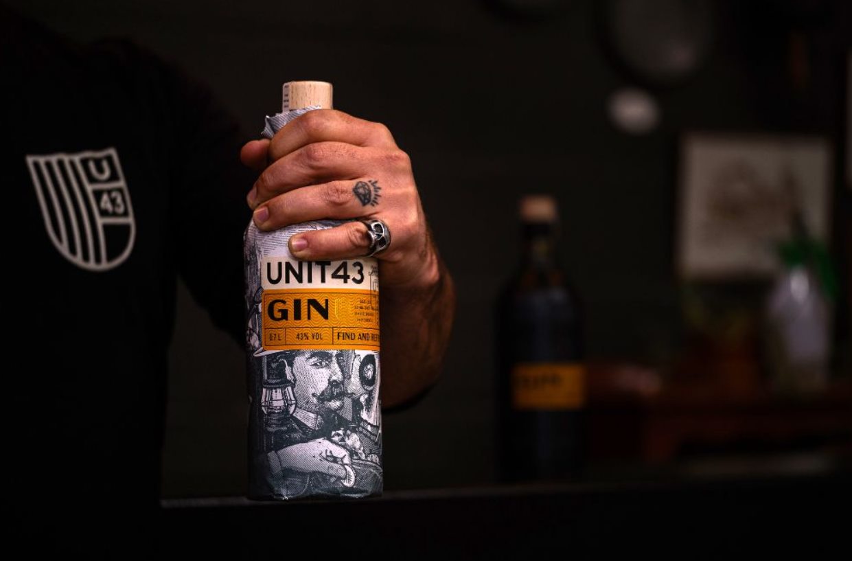 Hand mit Unit43 Dry Gin Flasche
