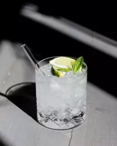 Cocktail mit Limette und Glasstrohhalm