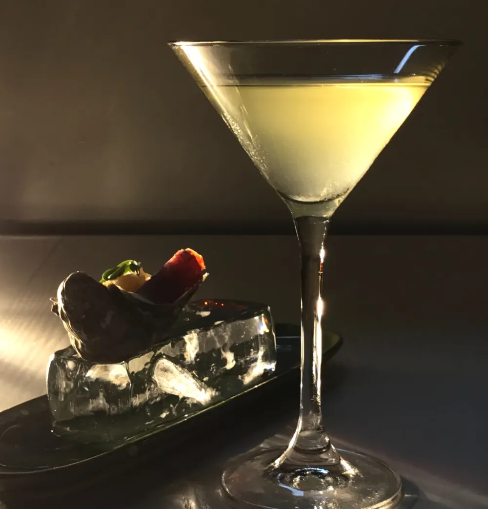 gelb-orangener Alaska Gin Cocktail im Martiniglas